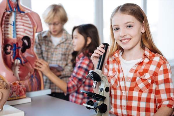 Alumnos con el cuerpo humano y microscopio